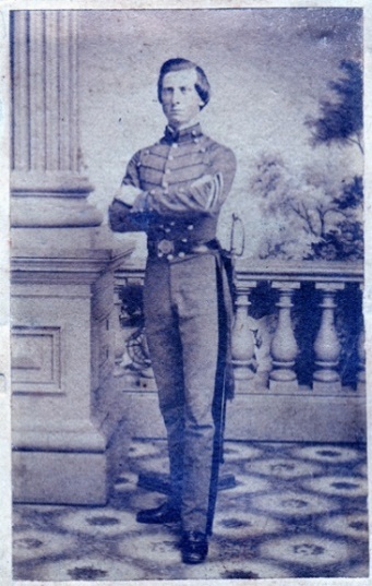 Cadet G. E. Haynesworth standing full length in a gray cadet uniform, arms folded, a sword at his side